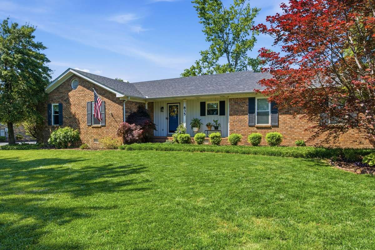 Beautifully maintained brick home with a welcoming front porch and picture-perfect setting.