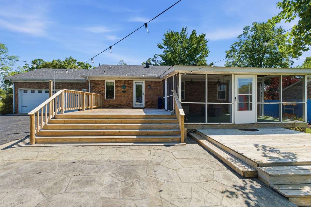 Expansive outdoor setup with deck, patio, and screened porch - - designed for gathering.