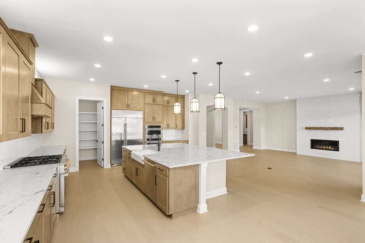View of gourmet kitchen, walk in pantry and family room from dining area.