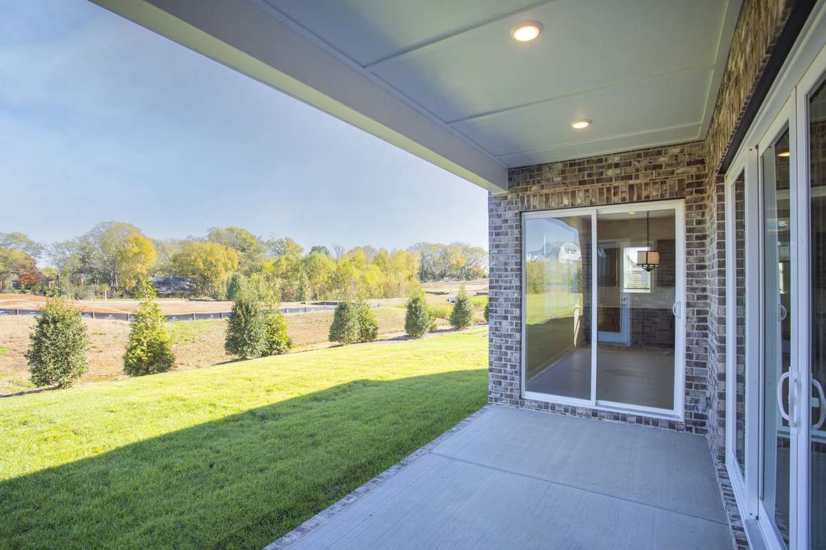 View of landscape and tree lined back yard from the patio