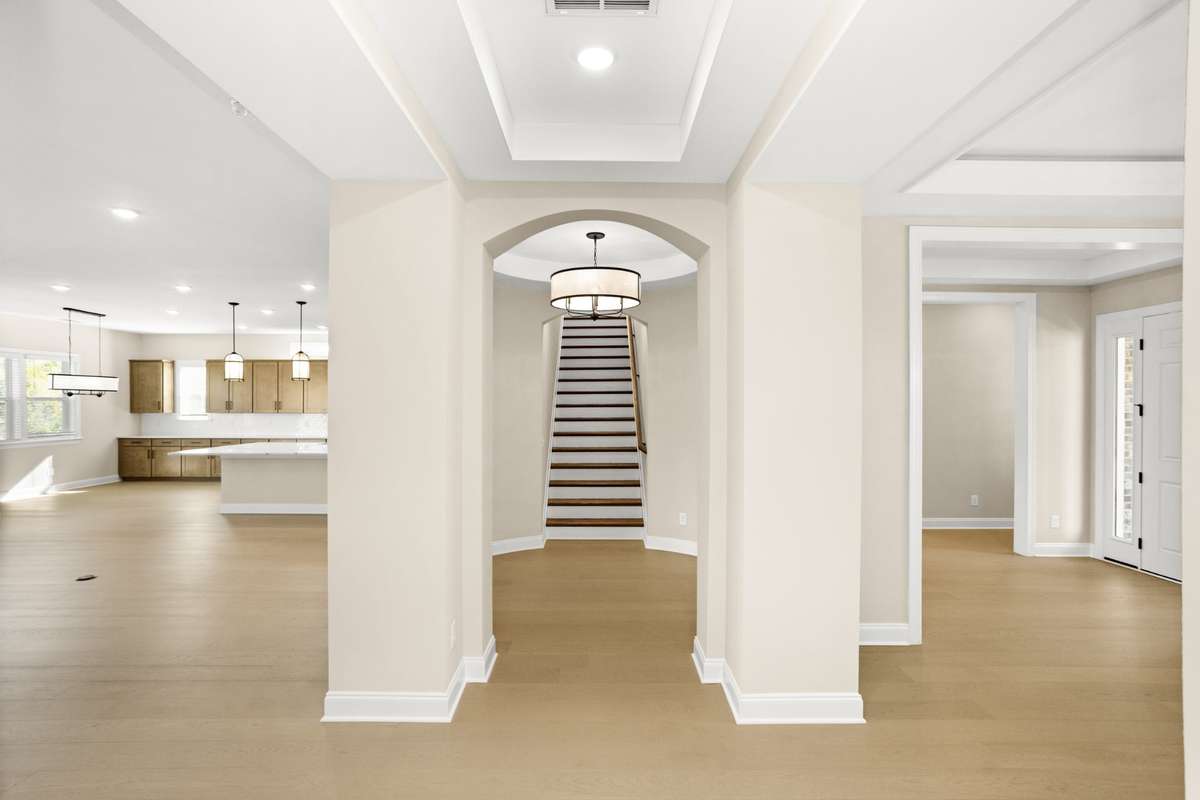 Stairway to 2nd floor, with the family room, kitchen and dining area to the left, and the foyer, bedroom 1, 2 and dining room to the right