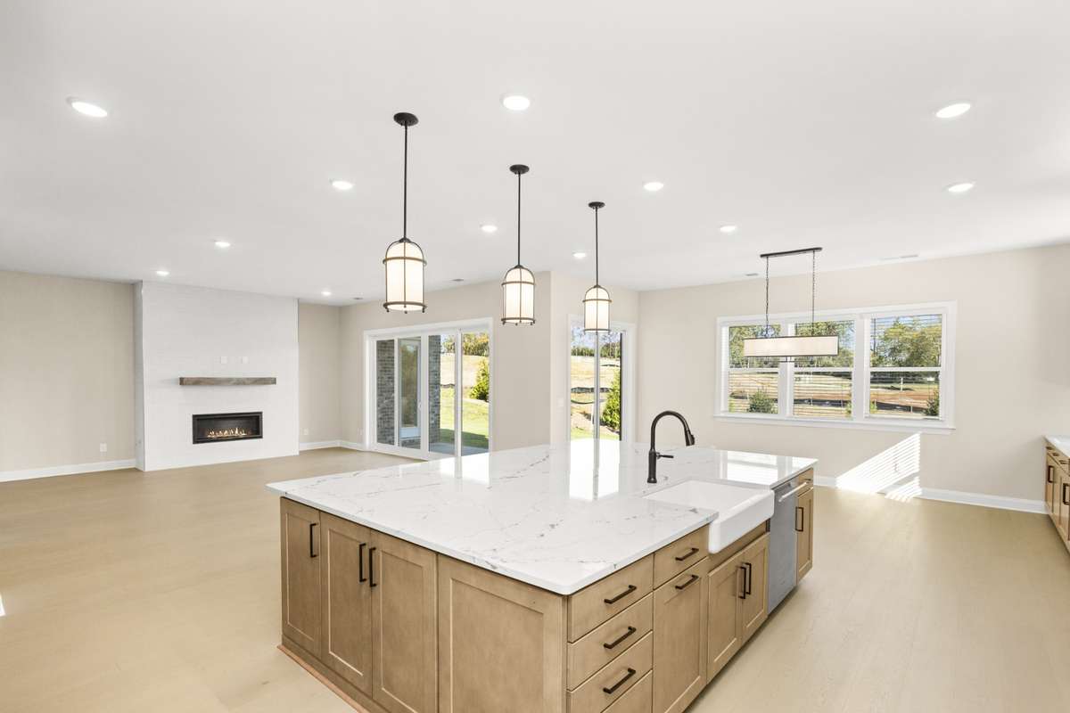 View of the family room, dining area and back yard from the kitchen