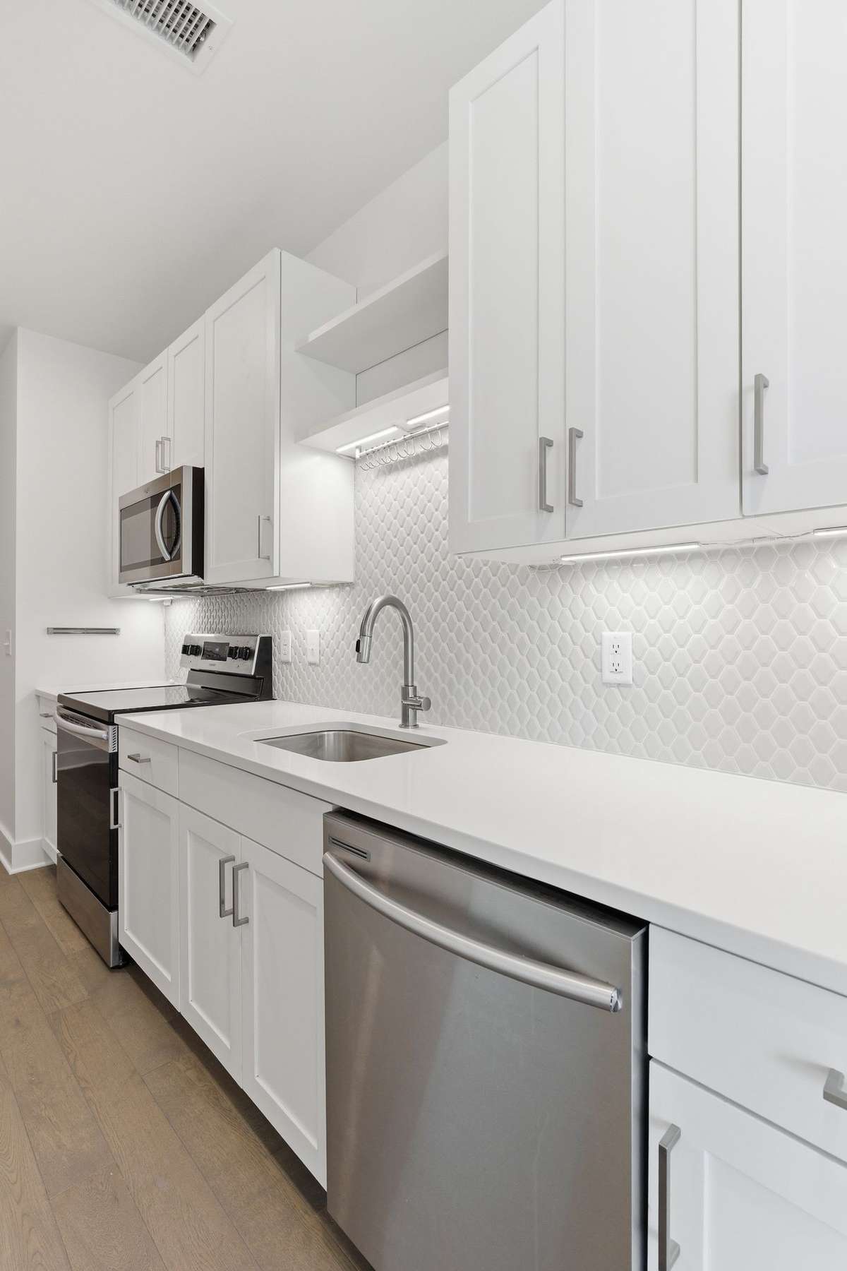 Quartz counters, tile backsplash and under-cabinet lighting