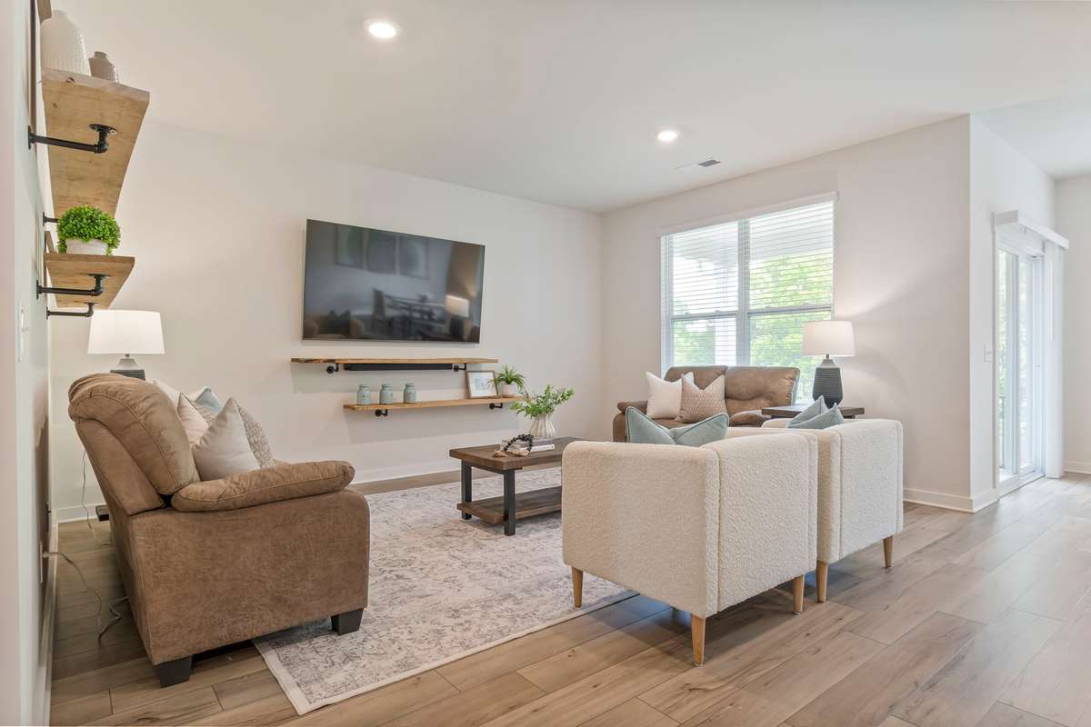 This living room features the wide-plank LVP flooring, natural lighting and wall space for plenty of furniture!