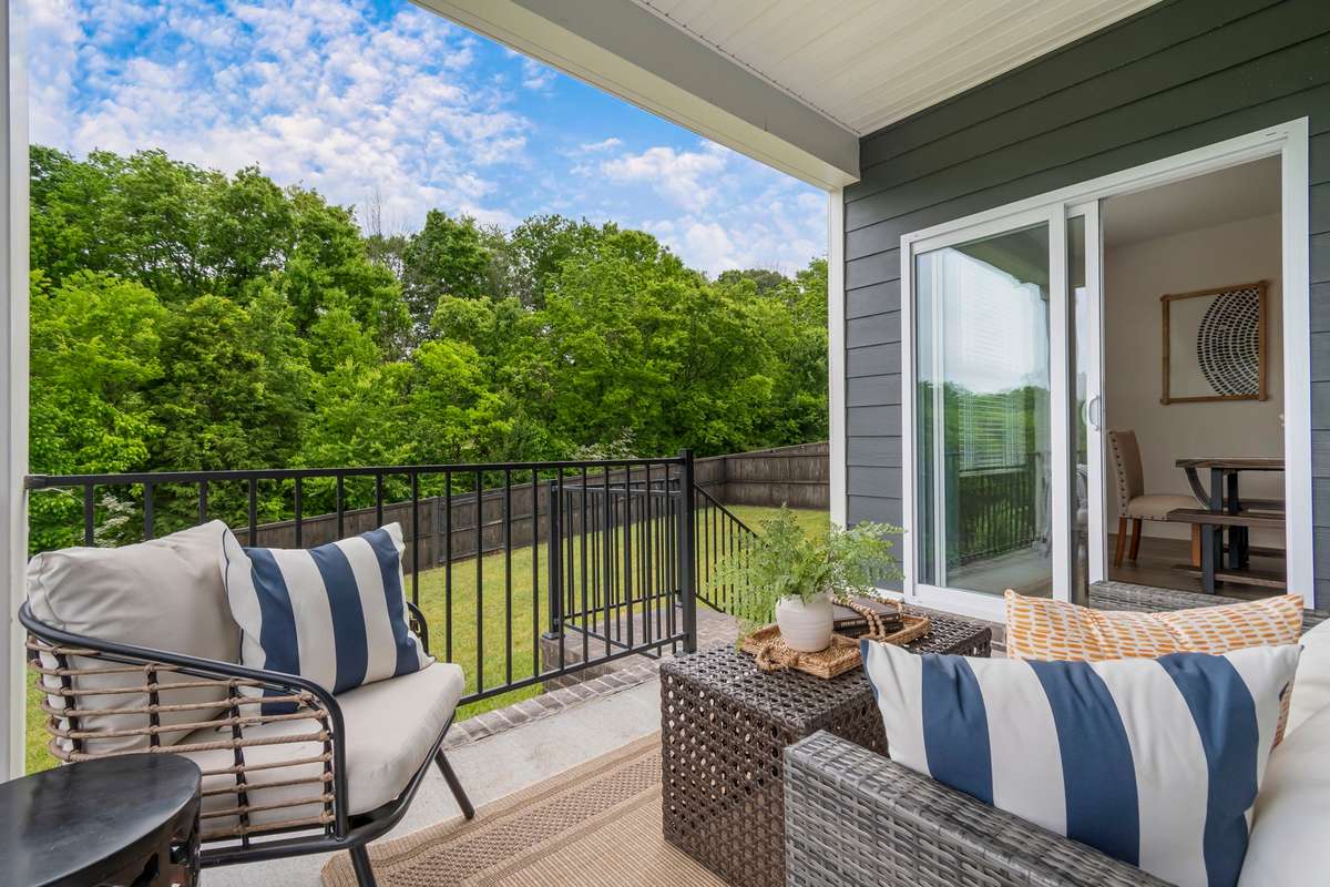 Enjoy peaceful outdoor living on the covered patio overlooking a private, tree-lined backyard.