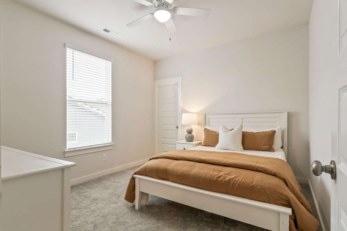Comfortable guest bedroom 3 with natural light and neutral tones and a walk-in closet!