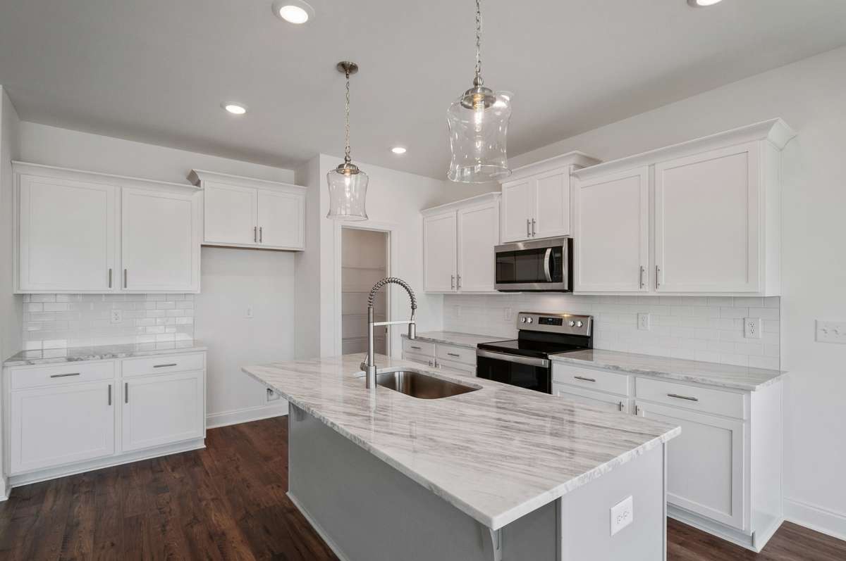 The well-appointed kitchen features a large island, placed perfectly beside the dining area & open great room...