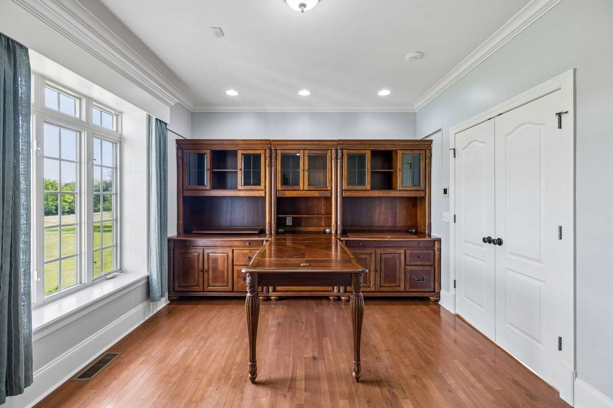 Office with gorgeous Build In Desk and Shelving off the Foyer with Double doors to the Primary Bedroom