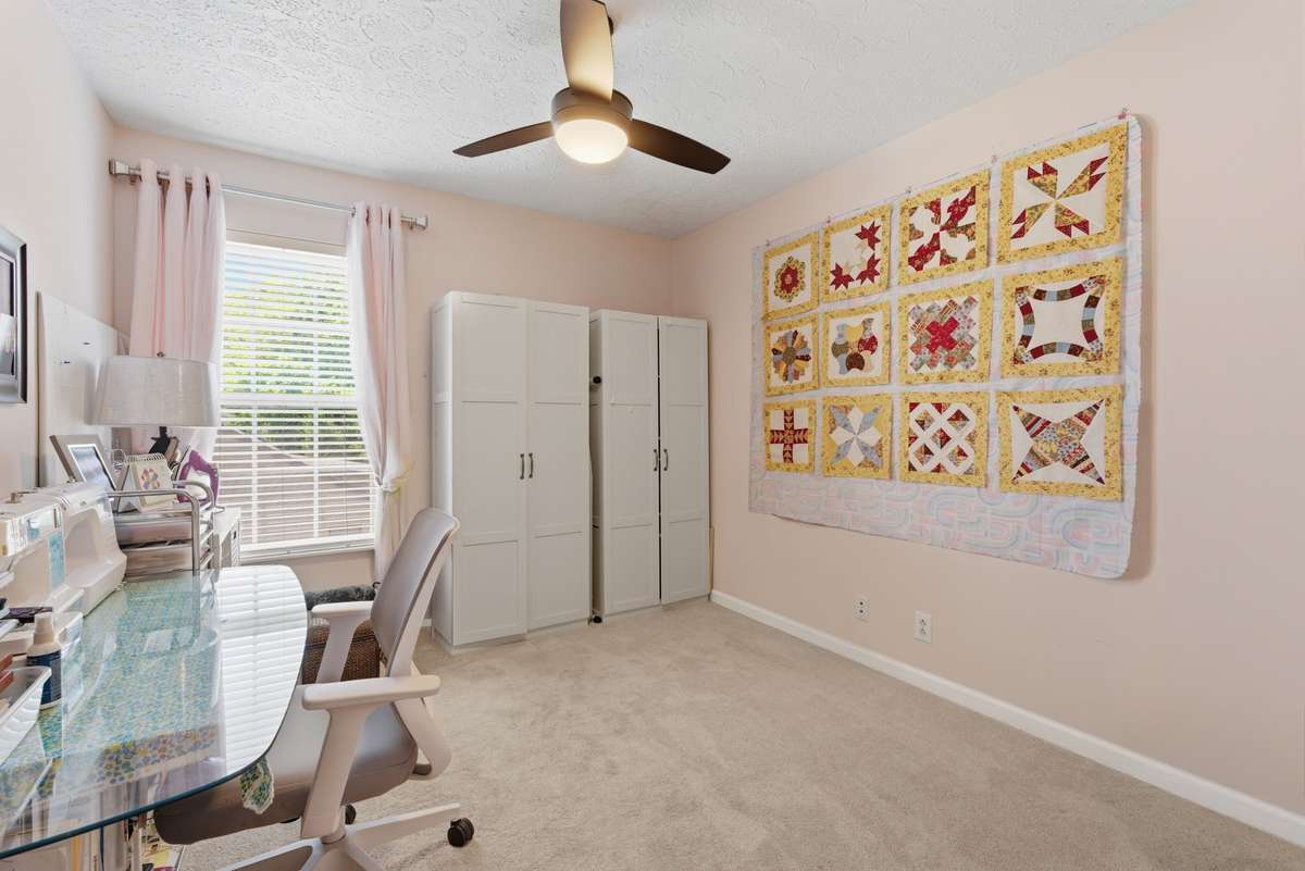 Upstairs corner back bedroom with walk-in closet. . . currently used as a craft room.  Newer carpet and ceiling fan.