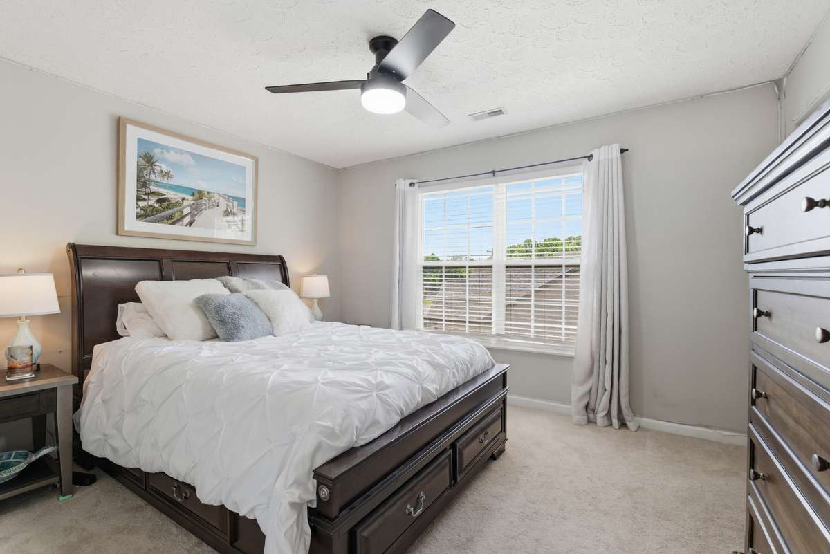 Upstairs middle spare bedroom with newer ceiling fan and carpet . . .overlooks backyard