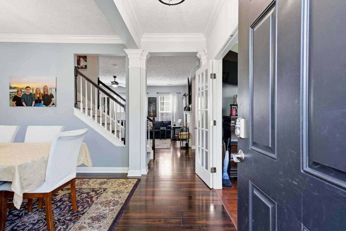 Beautiful entry into home with wood floors, new light fixture and formal dining room with double crown molding