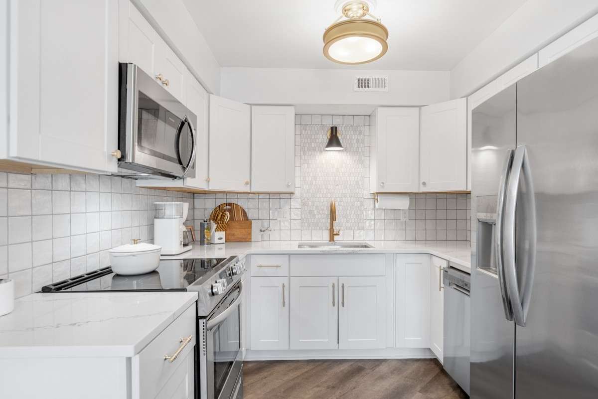 Stainless steel appliances include refrigerator, dishwasher range, and microwave