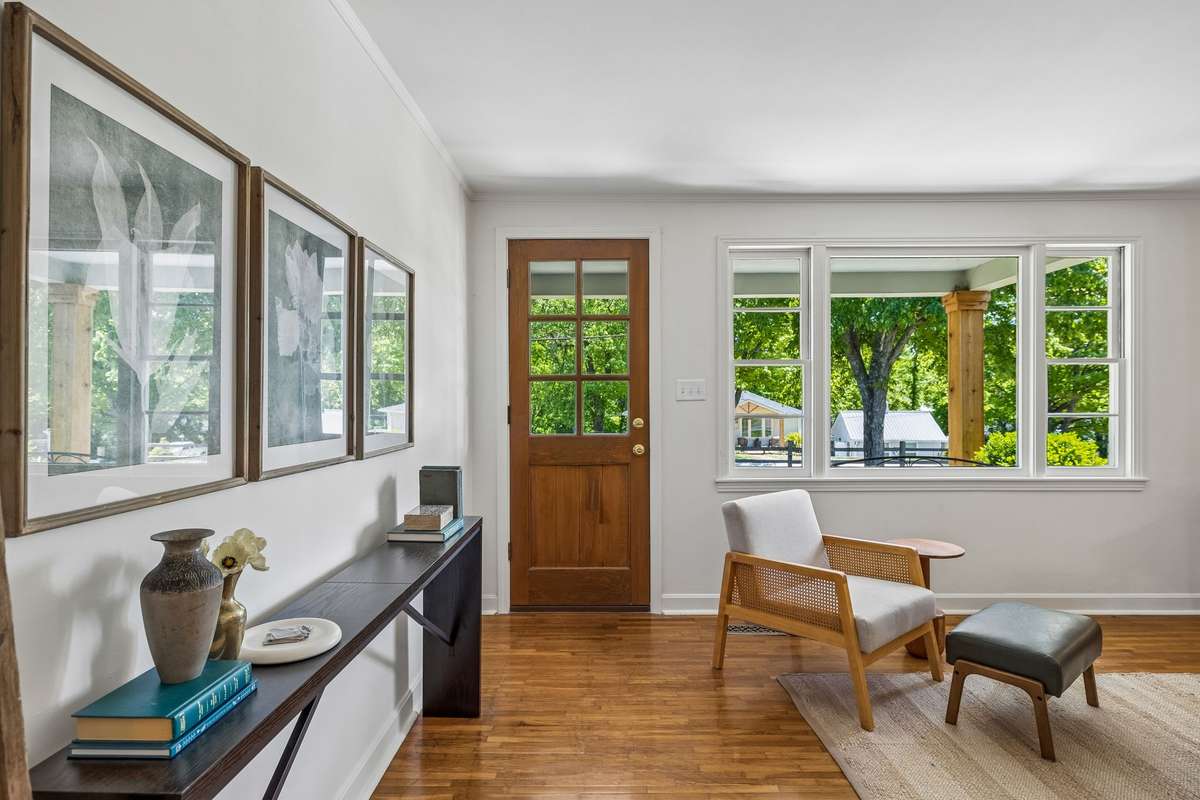 Enter into a bright, open-concept living room with soft, natural light from oversized front windows.