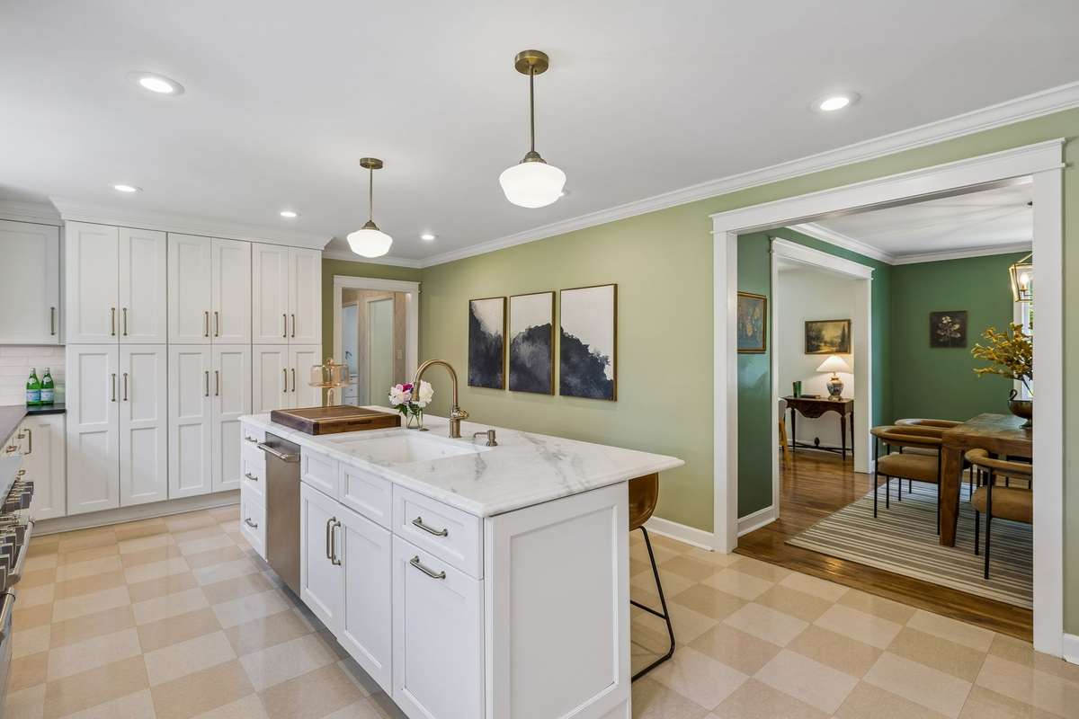 The oversized marble island is a statement piece providing prep space and eat-in seating.