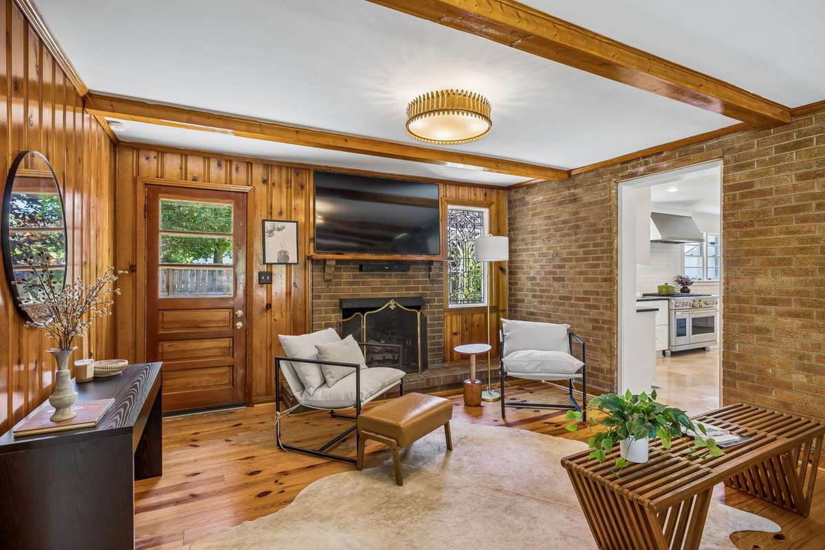 The inviting den blends original pine paneling and exposed brick.