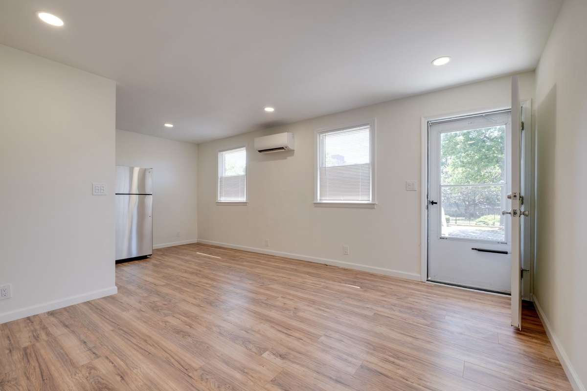 Unit C living toward entry with dining nook and kitchen to the left