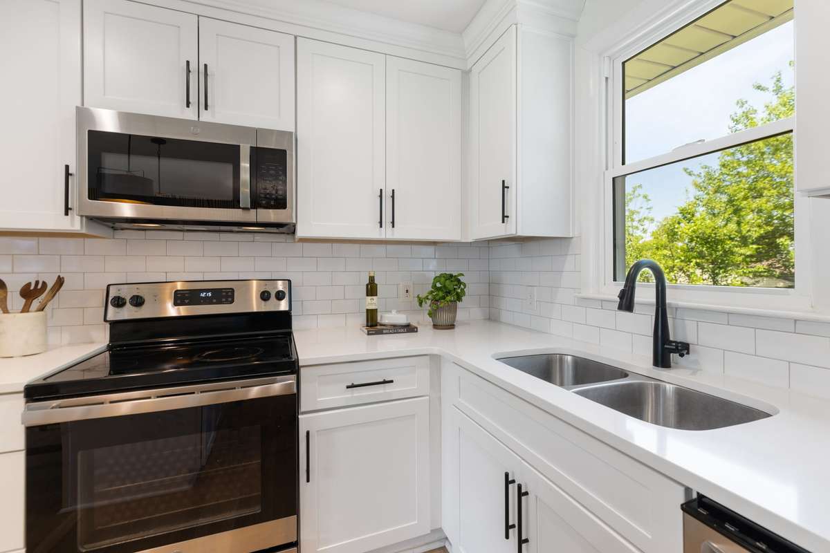 The Kitchen includes quartz countertops, subway tile backsplash, and energy-efficient stainless steel appliances. Bright kitchen sink window overlooks the level, fenced-in backyard.