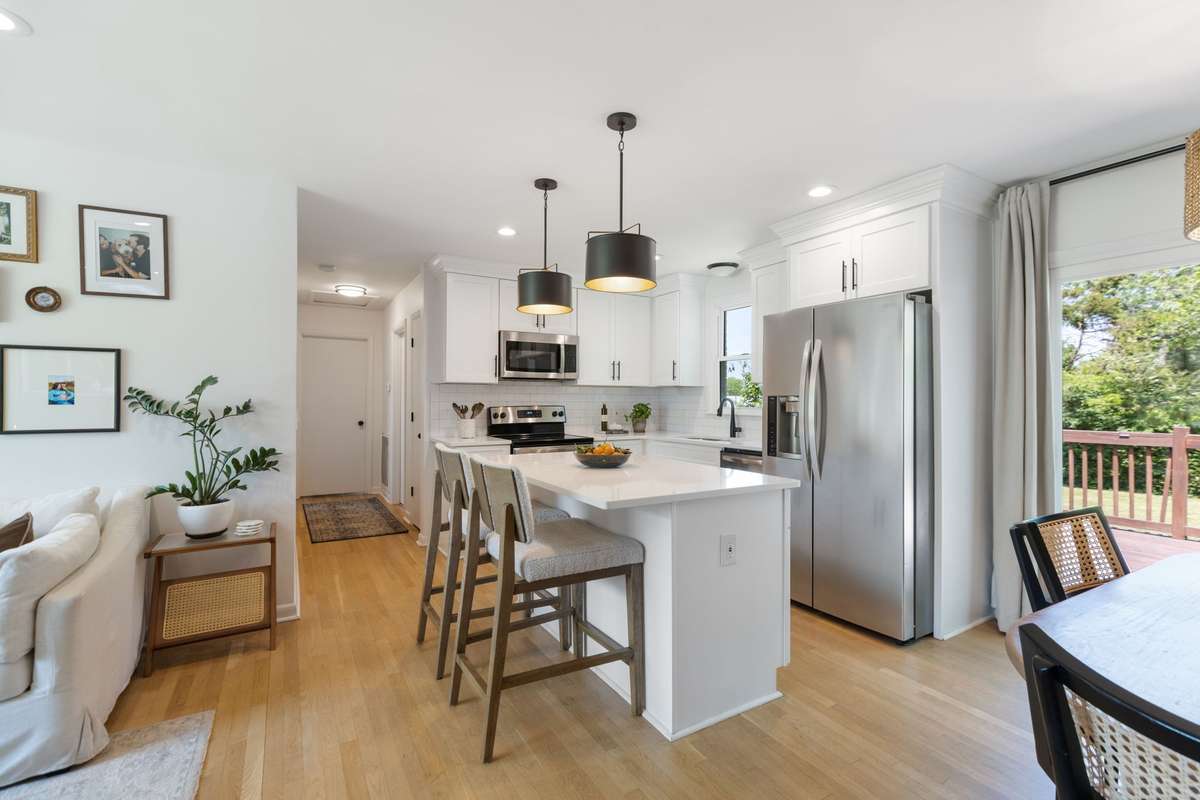 The Kitchen includes quartz countertops, subway tile backsplash, and energy-efficient stainless steel appliances. Bright kitchen sink window overlooks the level, fenced-in backyard.