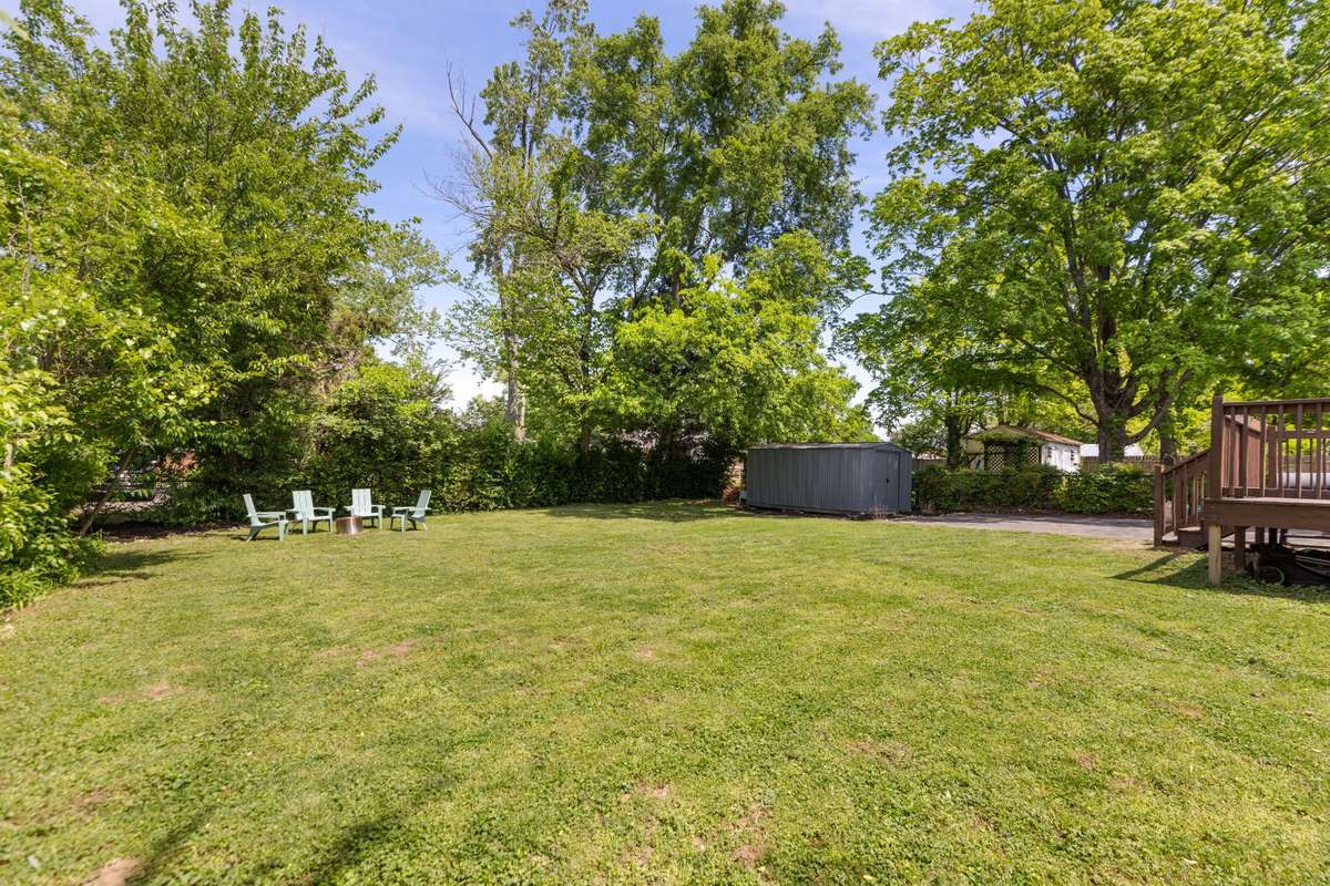 The level backyard backs to mature trees.