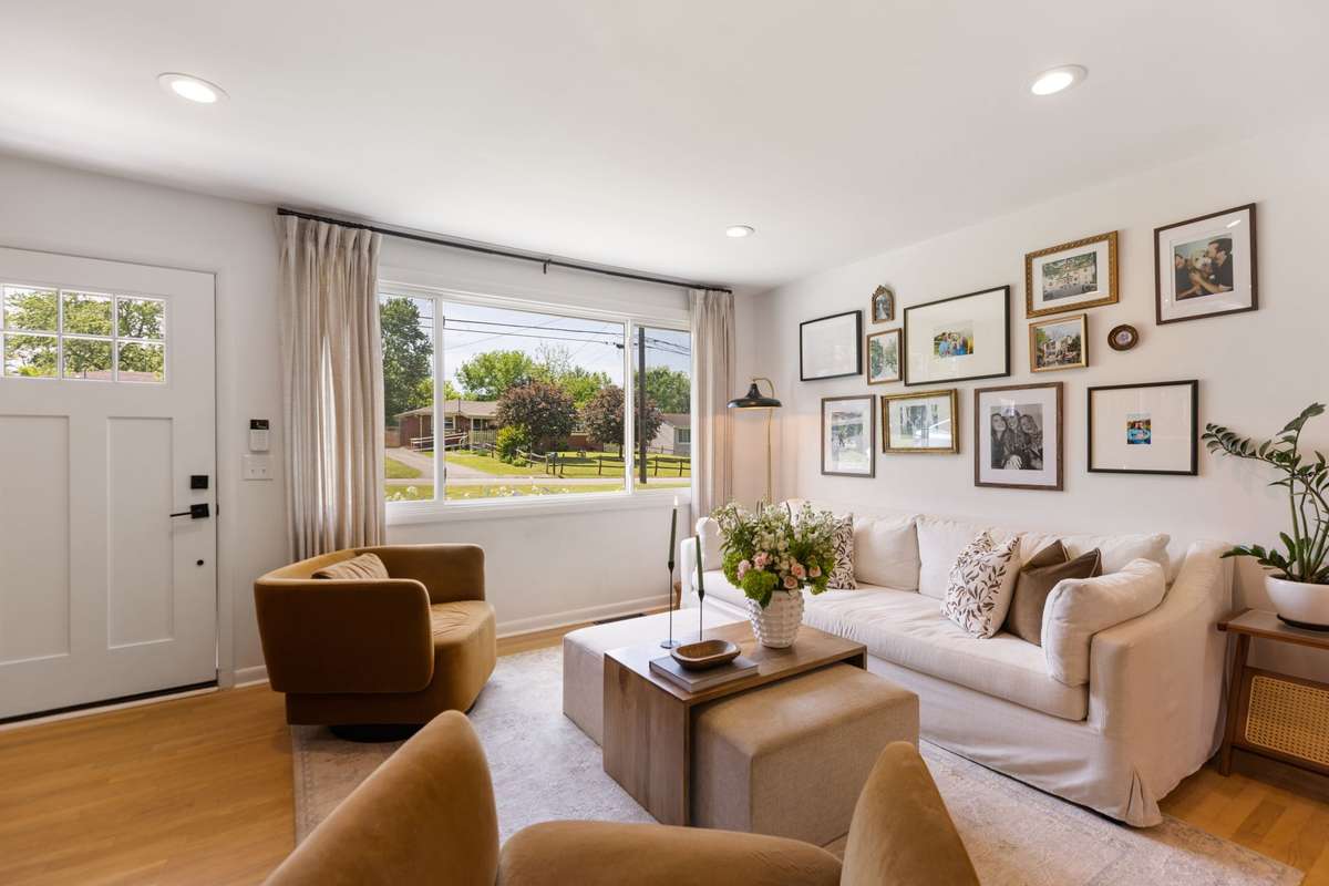 The Living Room includes a stunning wooden acoustic-paneled wall, an electric fireplace, an extra-large picture window, recessed lighting, and hardwood floors.