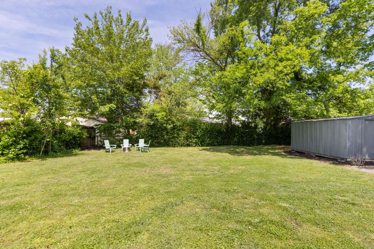 The level backyard backs to mature trees.