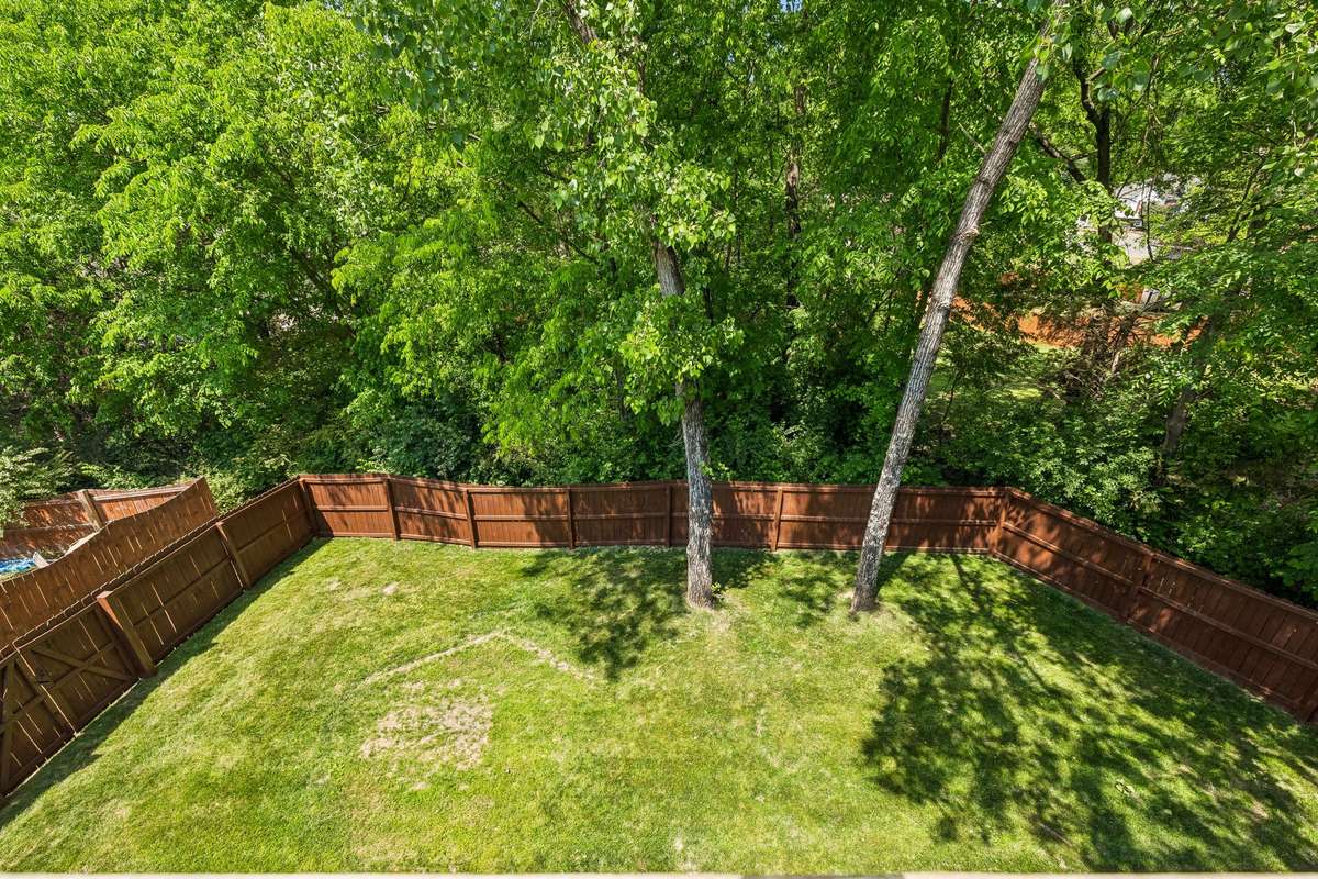 The fenced backyard is level with beautiful mature trees.
