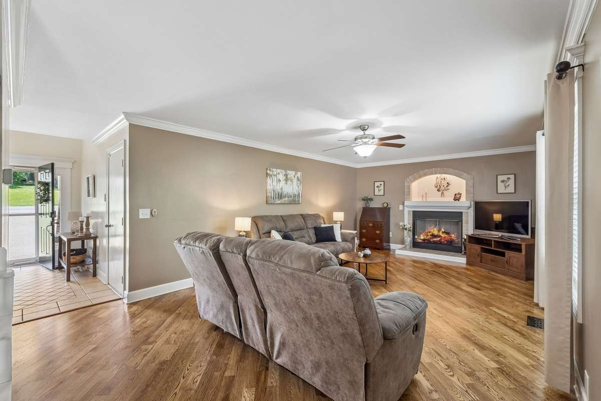 Oversized living room on main floor has new gleaming wood floors and electric fireplace with heater.
