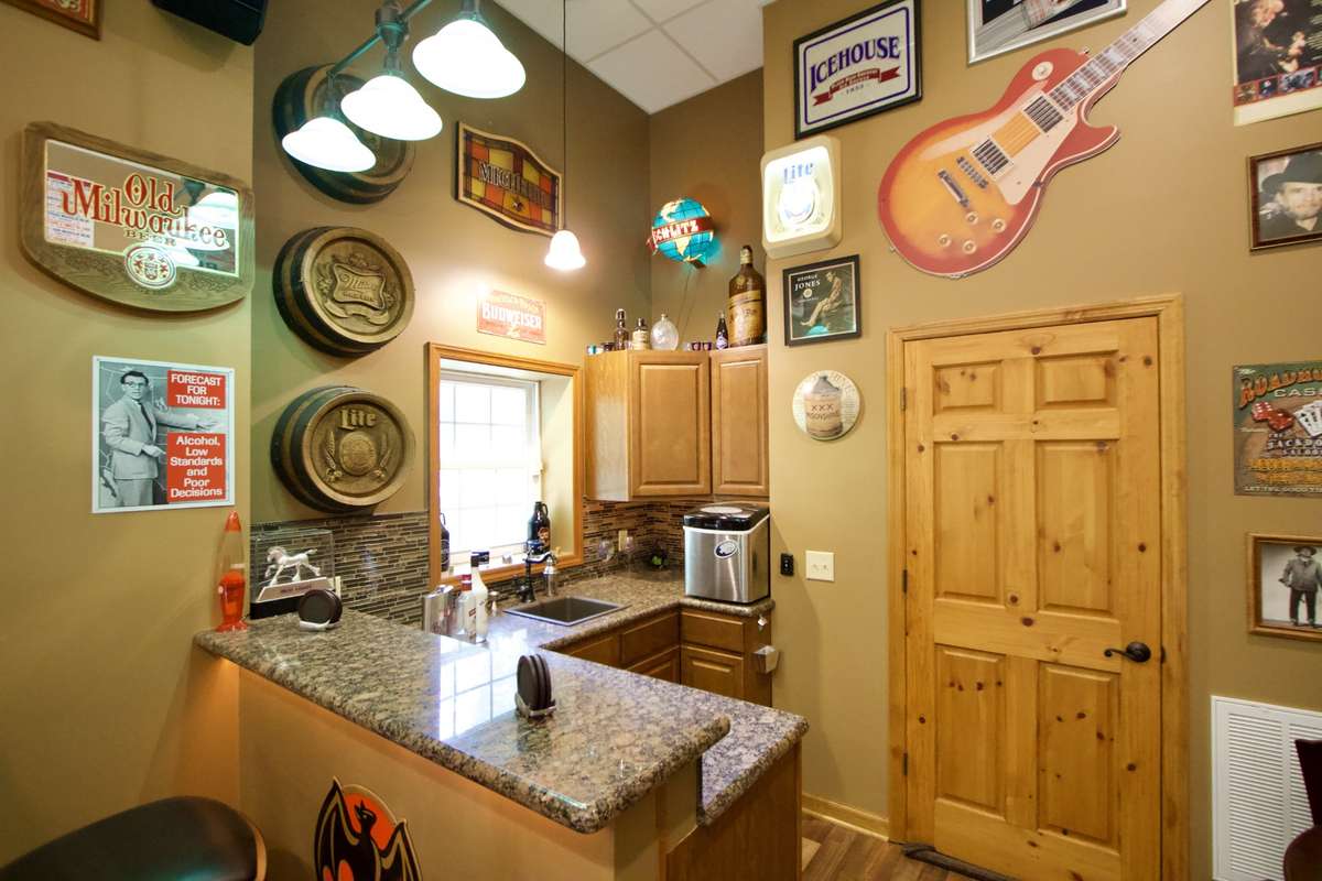 Granite counters, cabinets, wine cooler, sink. Door leads to a huge unfinished storage area. You could finish the storage area if you like.