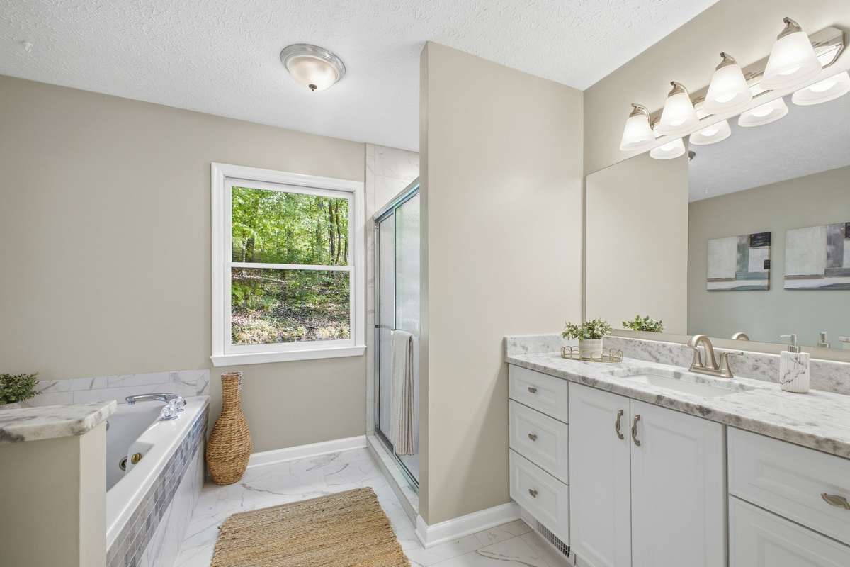 Primary bathroom is spacious with separate tile shower and tub.