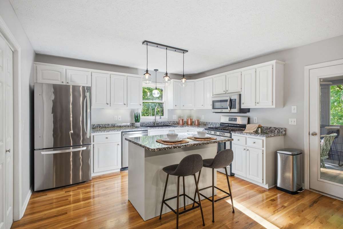 Kitchen and sunny and bright.  New lighting, lots of granite counter tops & cabinets and gas stove help to make this kitchen a very useful space.