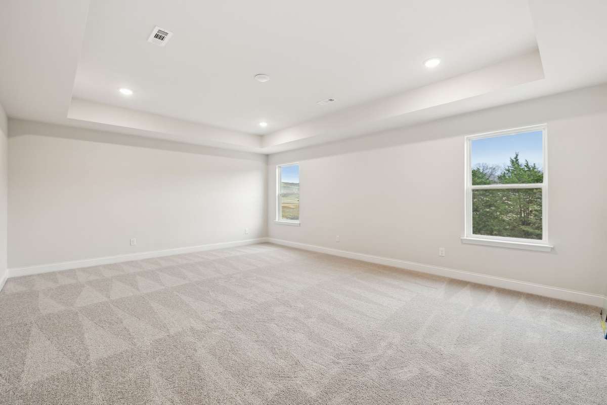 Located on the second floor, this large owner’s suite features a tray ceiling and recessed lighting, creating a bright and airy retreat.