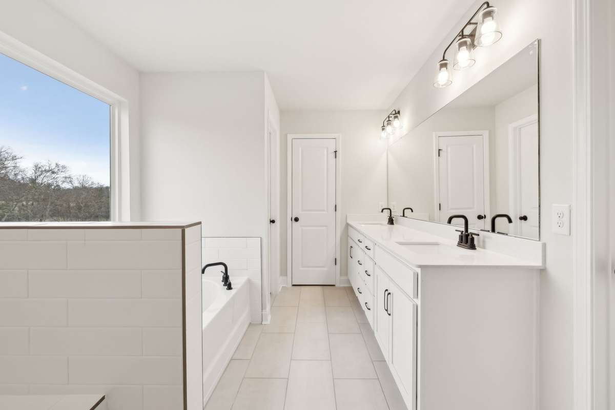 Double sinks set in quartz countertops and durable, stylish tile flooring are also included in the Owner's Bathroom.