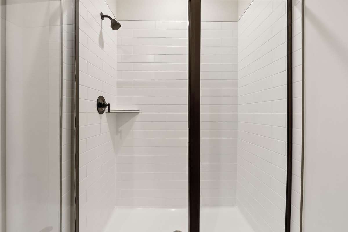 The 1st floor guest bathroom features a stylish tiled shower, offering both functionality and modern design.