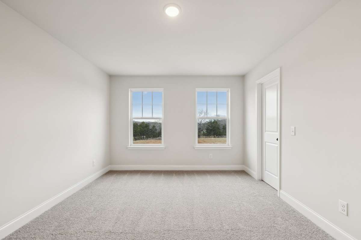 Two large windows flood Bedroom #3 with natural light, creating a bright and inviting atmosphere.
