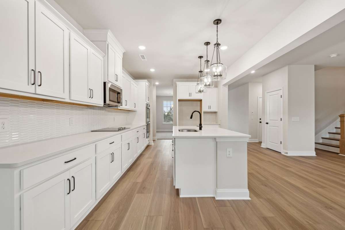 Designed for both style and function, this gourmet kitchen features a gas cooktop, double ovens, and black accents adding a modern, sophisticated touch. Perfect for home chefs and entertainers alike!