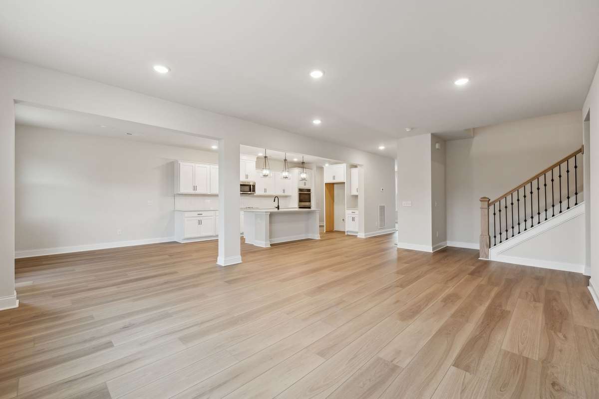 This photo showcases the home’s beautifully designed open-concept layout, where the kitchen, breakfast area and great room flow seamlessly together. Perfect for modern living, the open space allows for effortless entertaining and everyday connection.