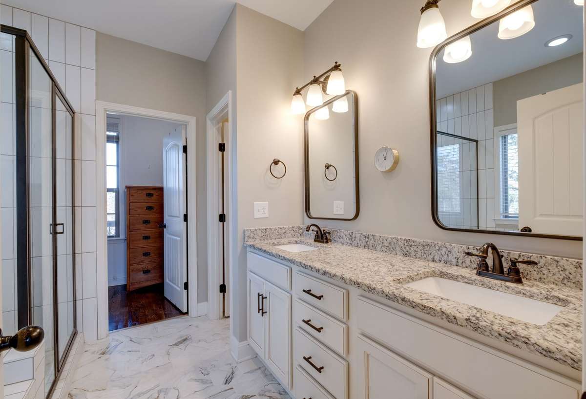 Granite Double Vanities + Tile Floor in Primary Bathroom