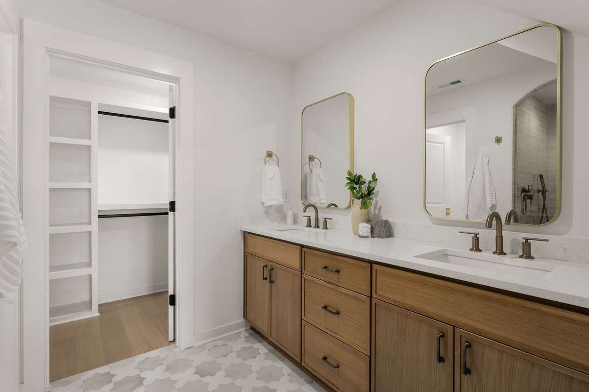Primary bathroom with dual vanities + walk-in closet