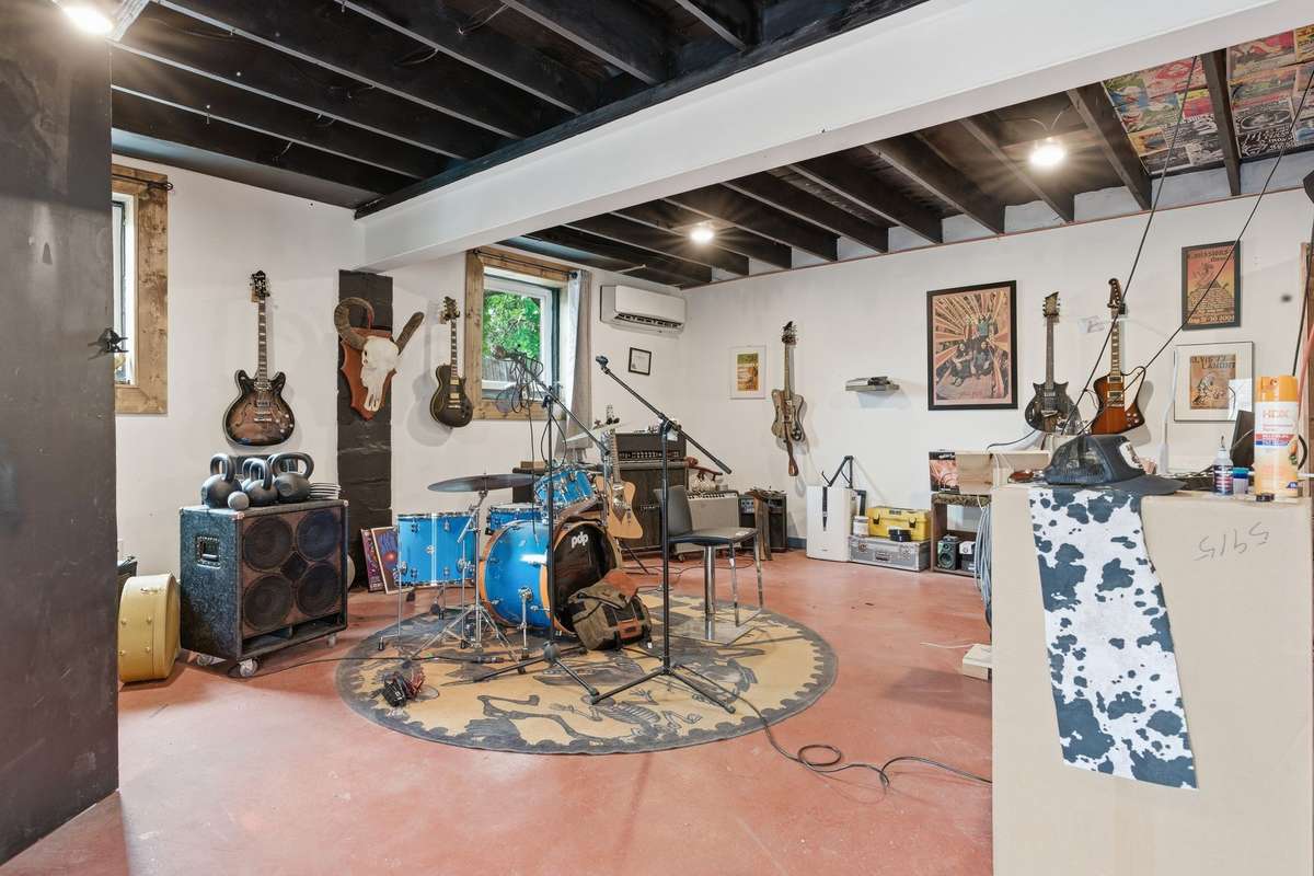 Detached studio is a large open space. The sellers converted it from a garage into a heated and cooled space w/ double drywall and sound proof style windows.