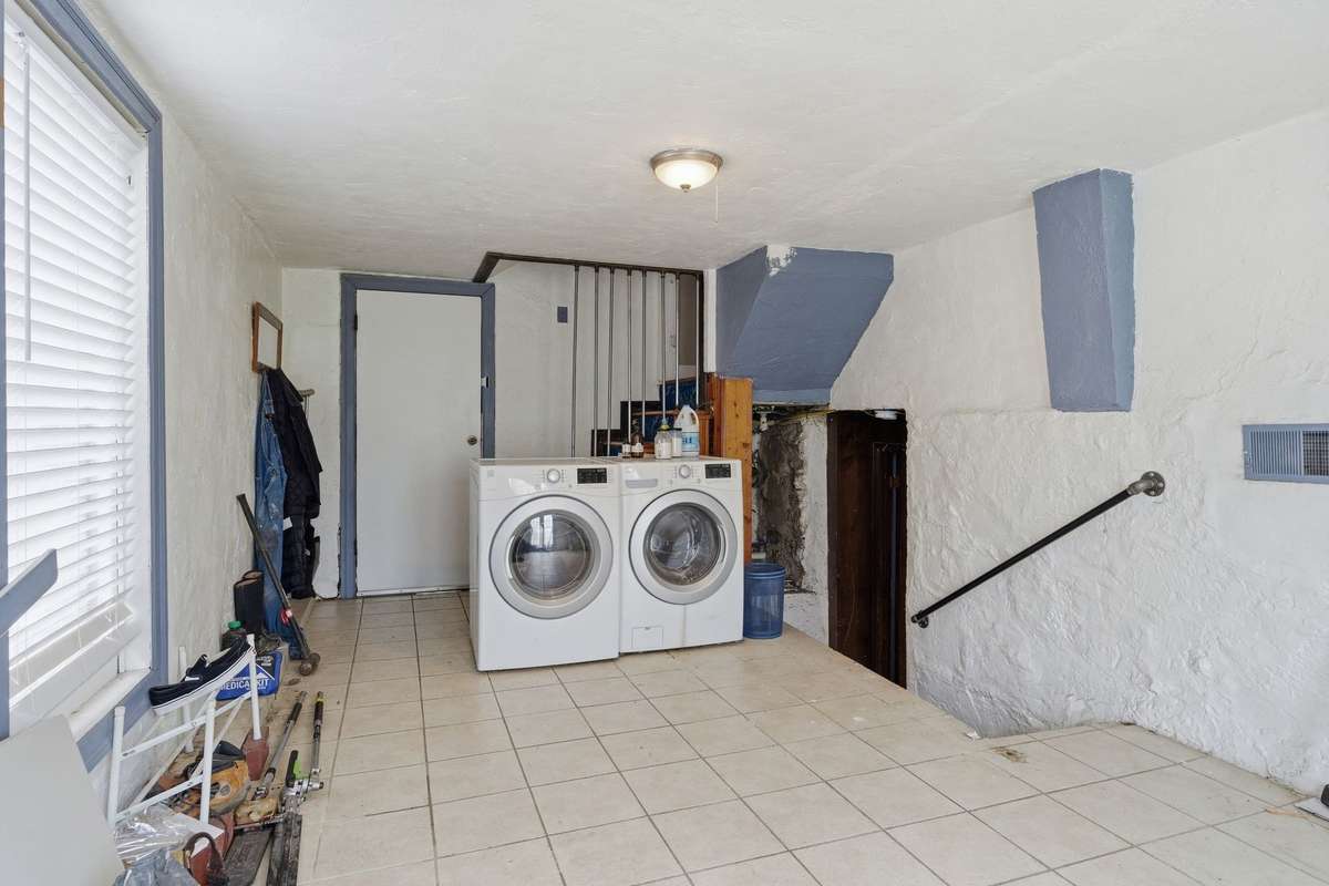 This area serves as laundry room and mudroom and side entrance. There is a door to the backyard in this room too. The stairwell to the right takes you to the lower level.