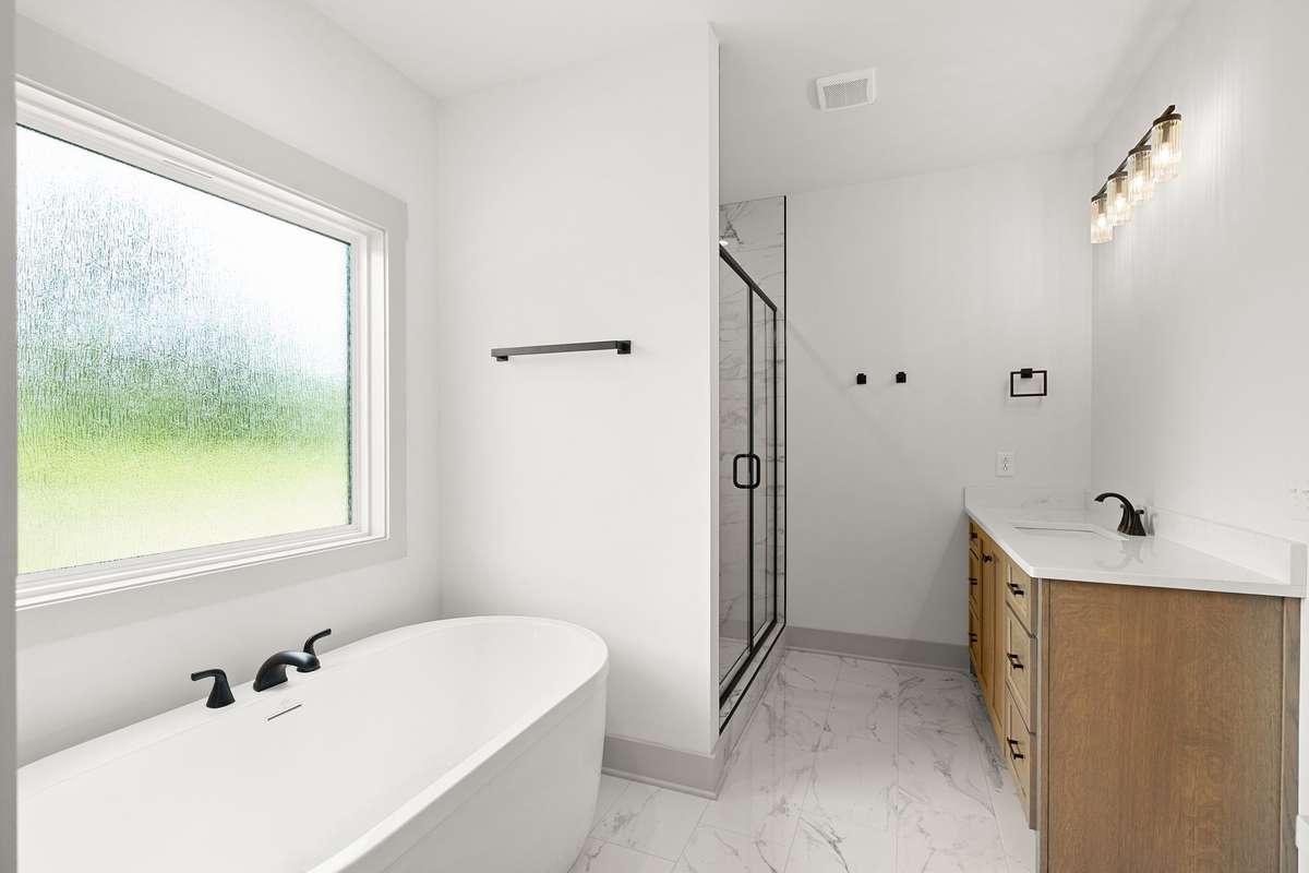 Free standing soaking tub with his / hers vanities.