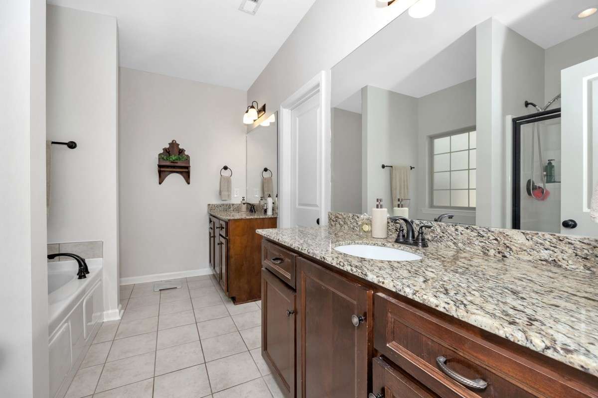 Primary Bathroom- tile flooring, granite double vanities, walk in closet, separate shower, whirlpool
