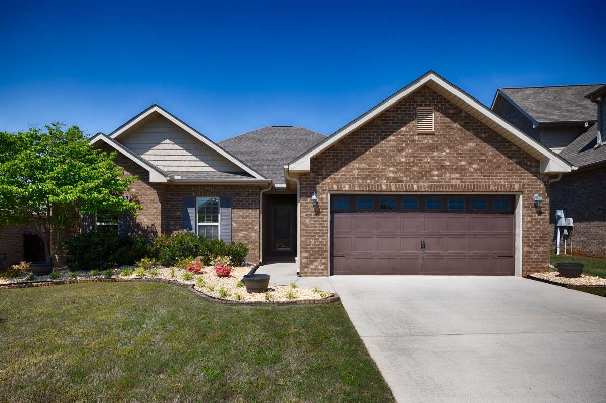 Front of house - Full brick, concrete driveway and sidewalk, beautiful landscaping, attached 2-car front facing garage with single rollup door