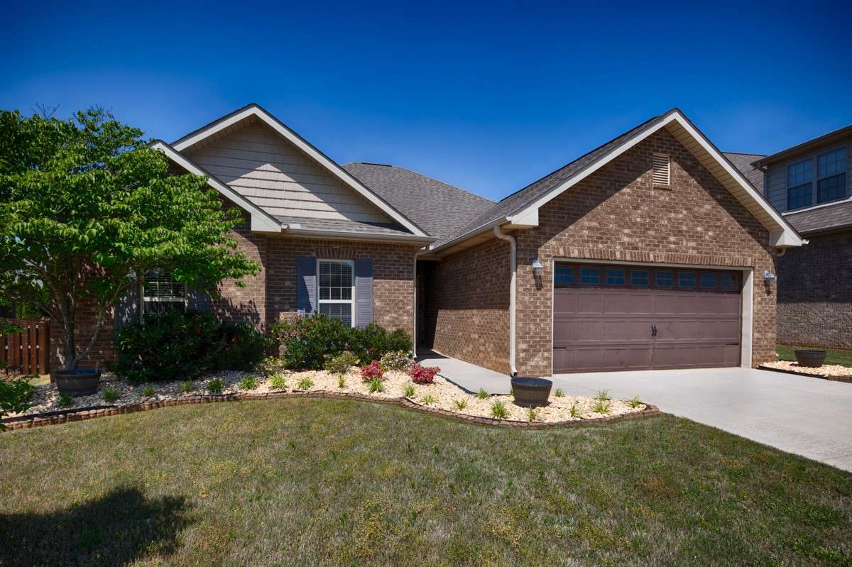 Front of house - Full brick, concrete driveway and sidewalk, beautiful landscaping, attached 2-car front facing garage with single rollup door
