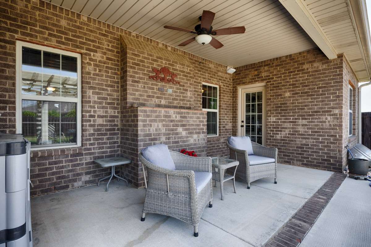 Back of house- Beautifully landscaped back yard with privacy fence, open patio with pergola, covered back porch with ceiling fan