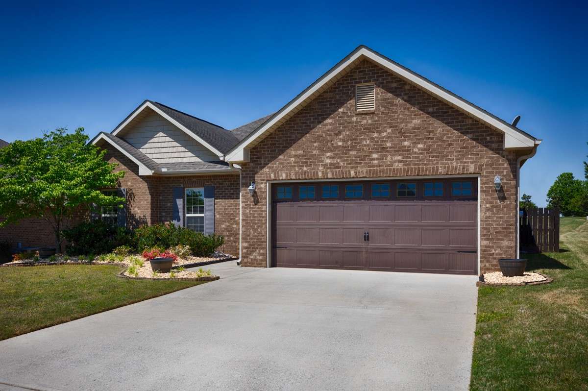 Front of house - Full brick, concrete driveway and sidewalk, beautiful landscaping, attached 2-car front facing garage with single rollup door