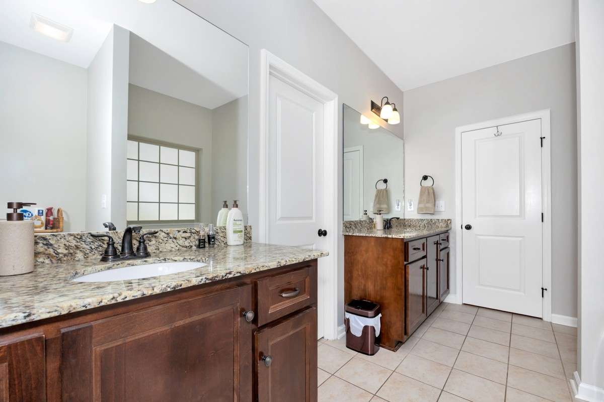 Primary Bathroom- tile flooring, granite double vanities, walk in closet, separate shower, whirlpool