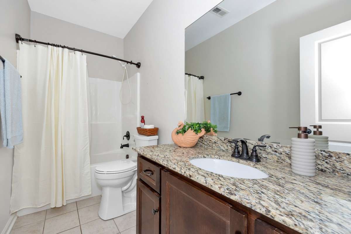Bathroom- tile flooring, granite vanity, tub/shower combo