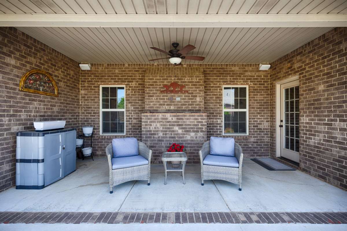Back of house- Beautifully landscaped back yard with privacy fence, open patio with pergola, covered back porch with ceiling fan