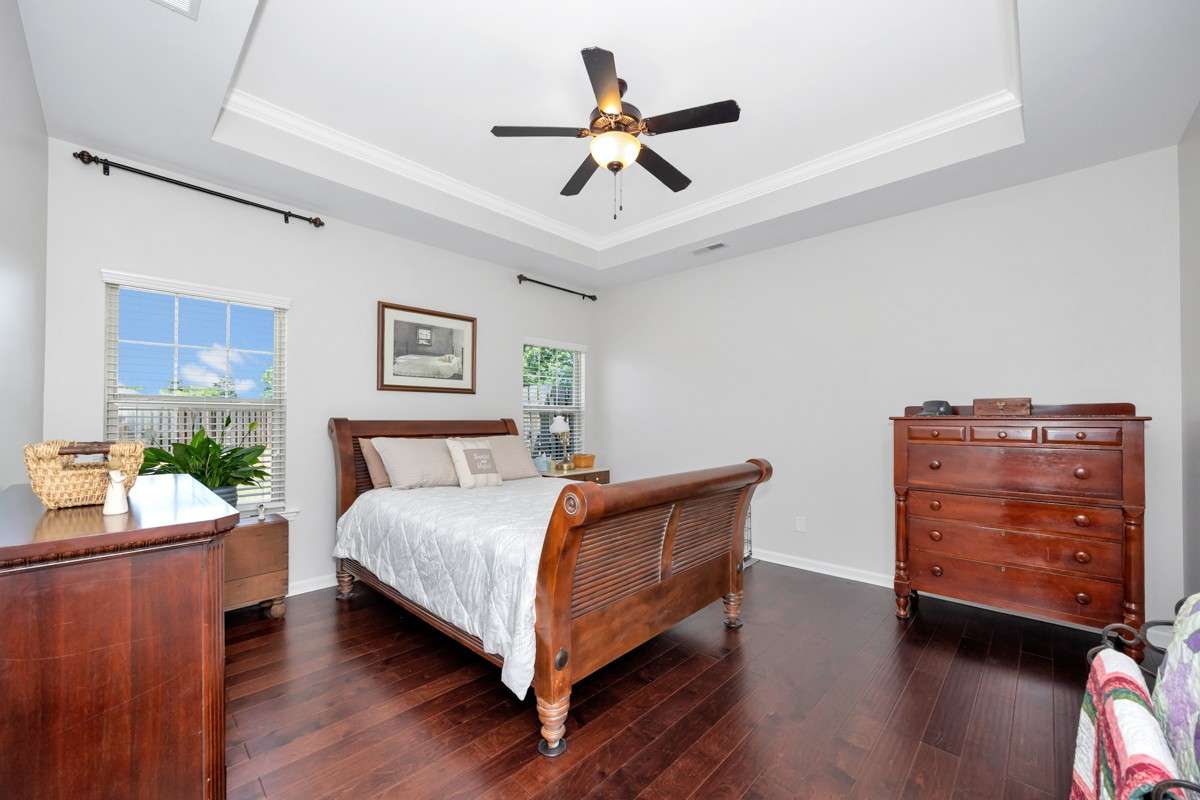 Living Room- wood flooring, trey ceiling, ceiling fan, crown molding